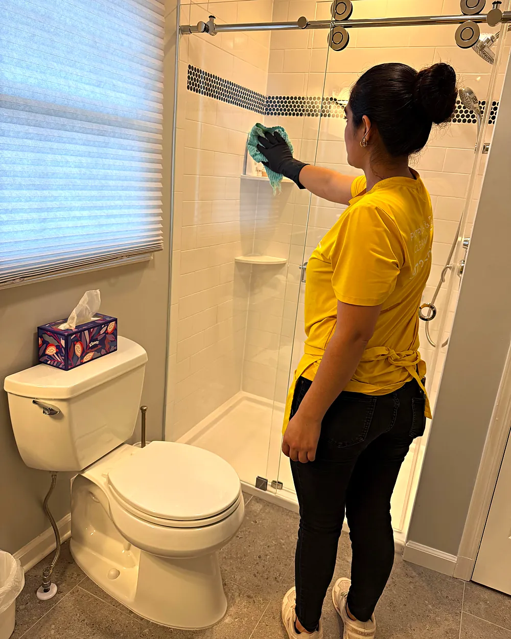 Cleaner wiping a shower glass door, house cleaning in Denville, NJ
