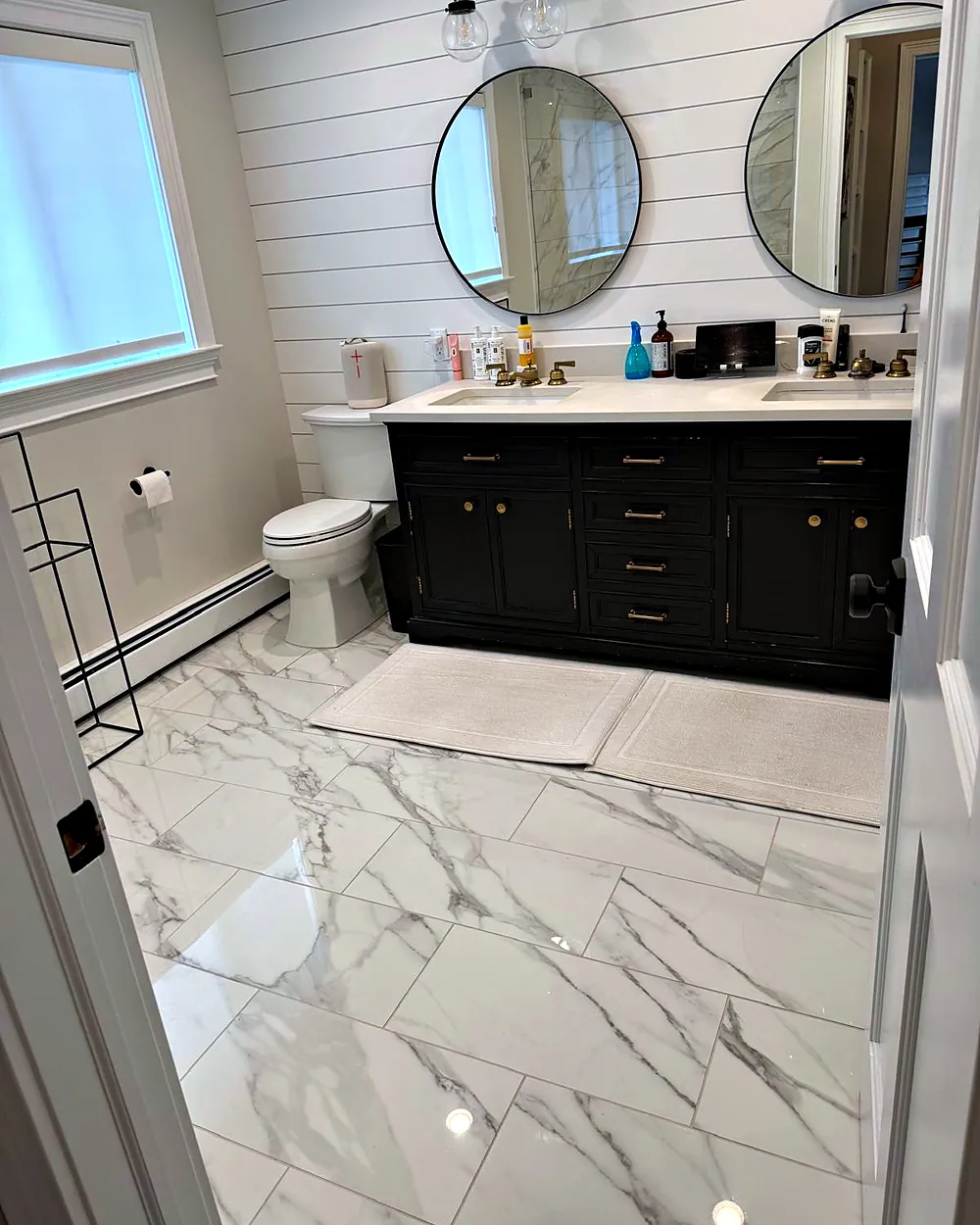 Bathroom with round mirrors and marble floor, house cleaning in Morris Plains, NJ