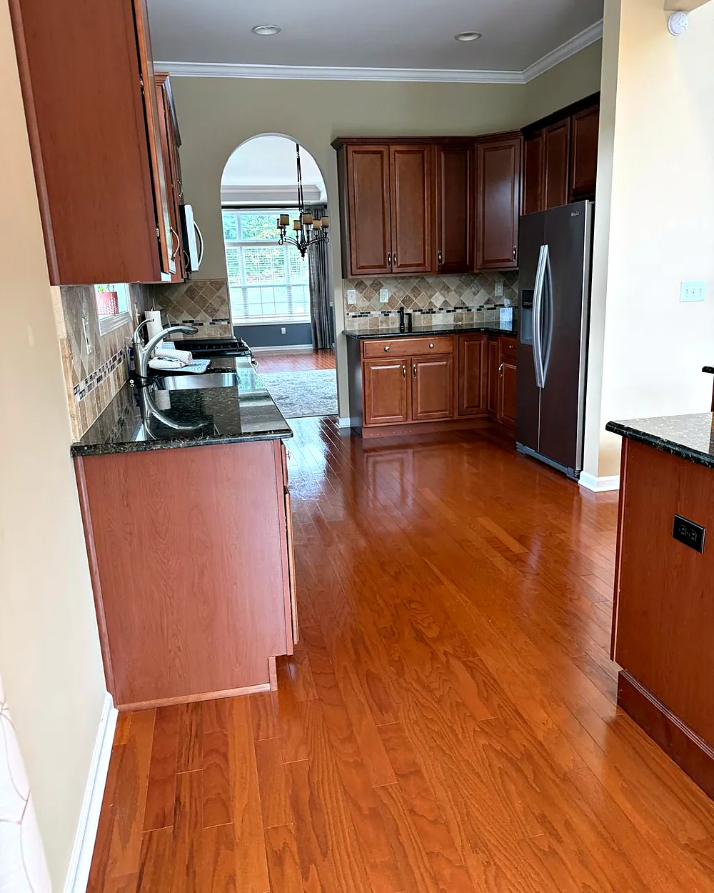 Kitchen with arched window and wood cabinets, house cleaning in Morristown, NJ