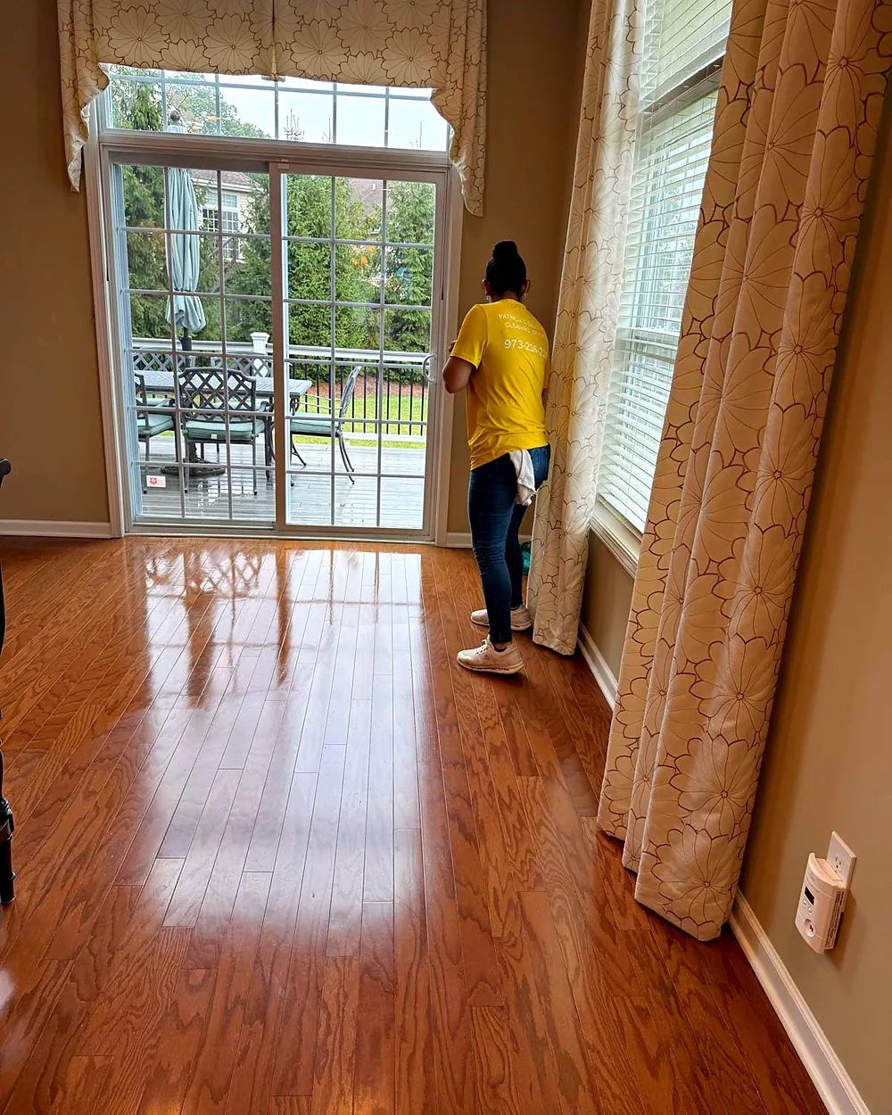 Cleaner wiping a sliding glass door, house cleaning in Mountain Lakes, NJ