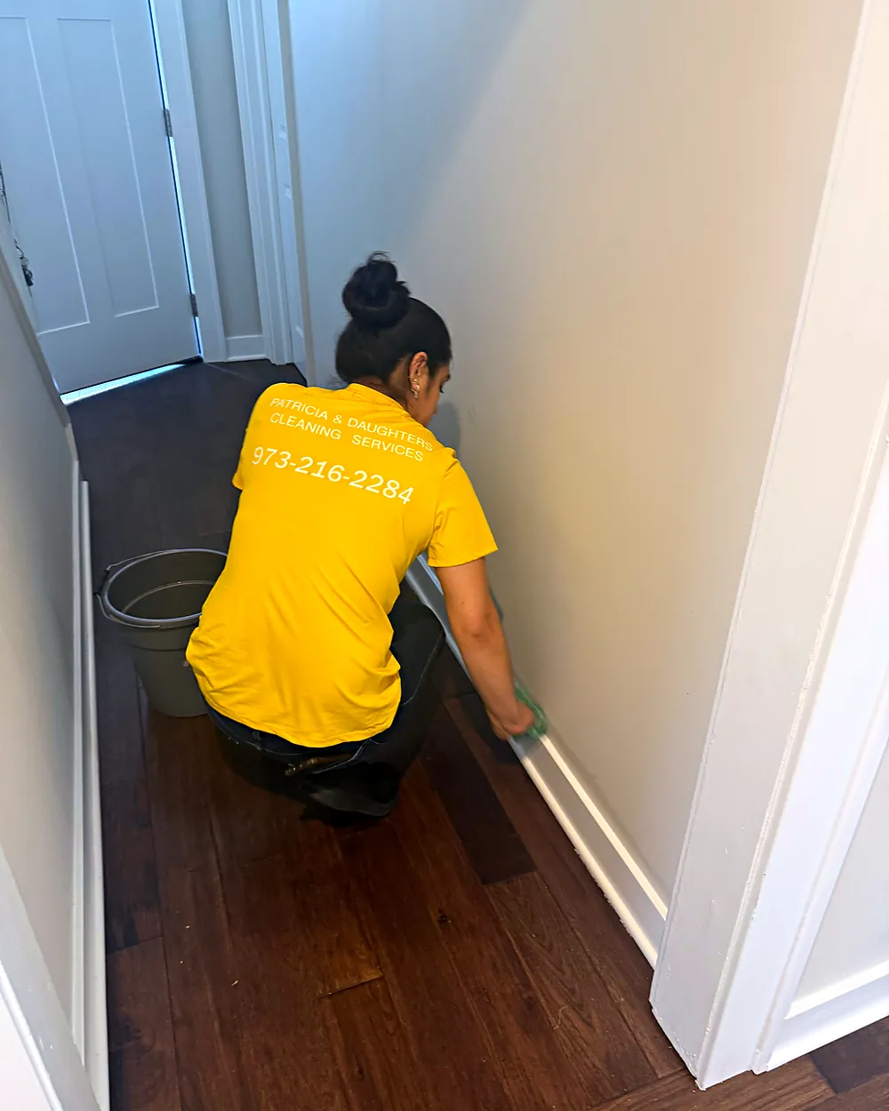 Cleaner wiping baseboards, house cleaning in Peapack, NJ