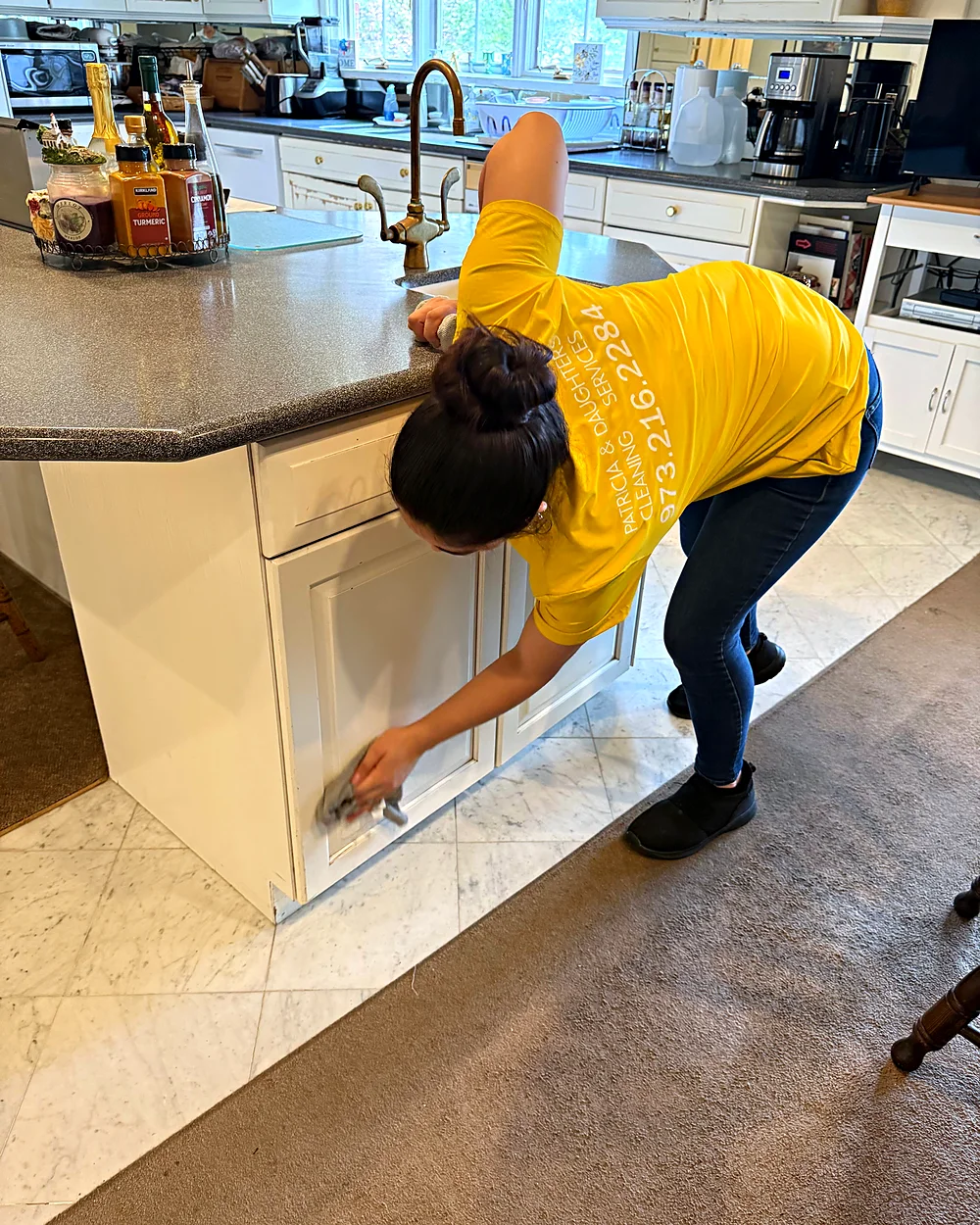 Cleaner wiping kitchen cabinets in a Sparta, NJ home